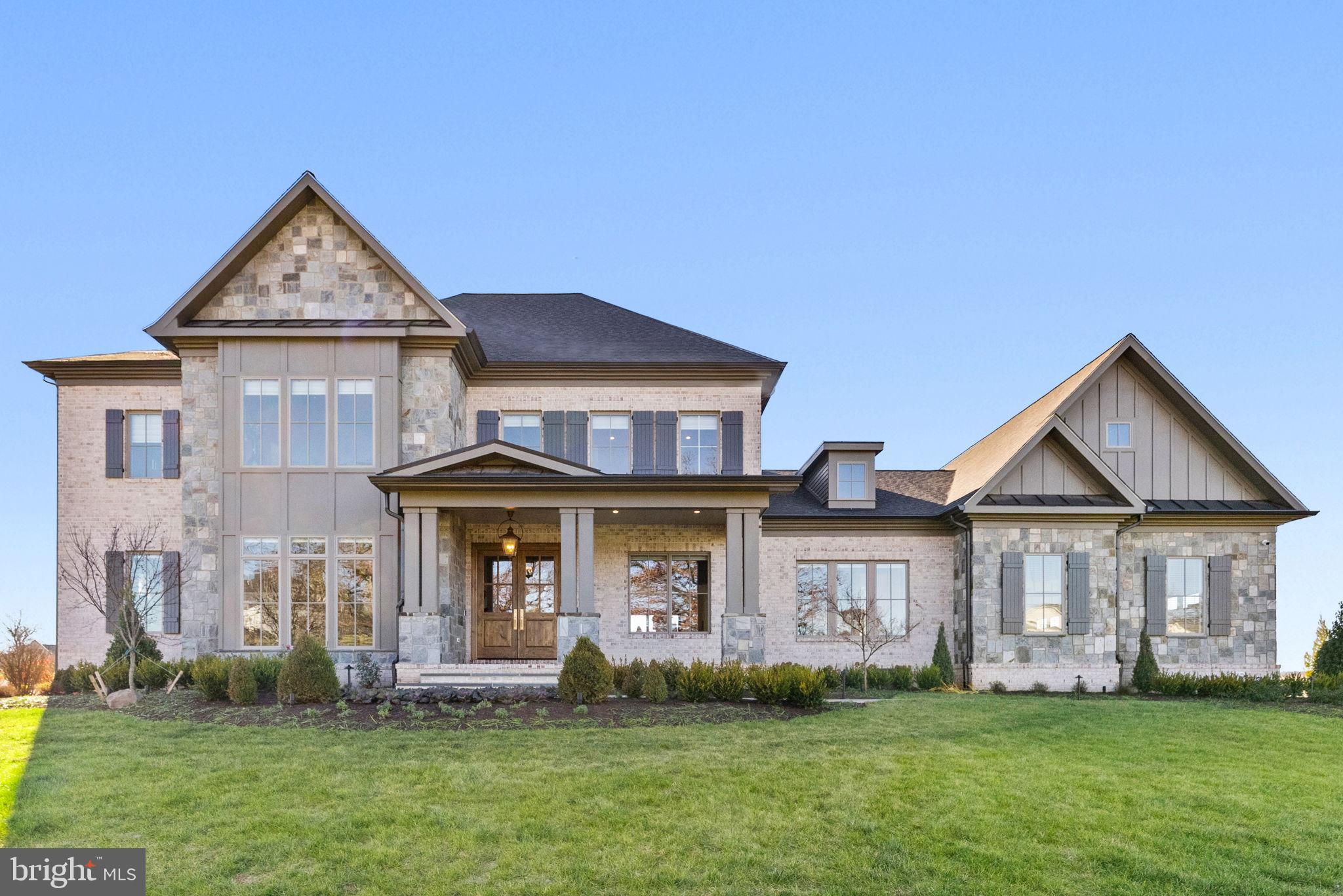 Elegant stone-clad home with lush greenery.