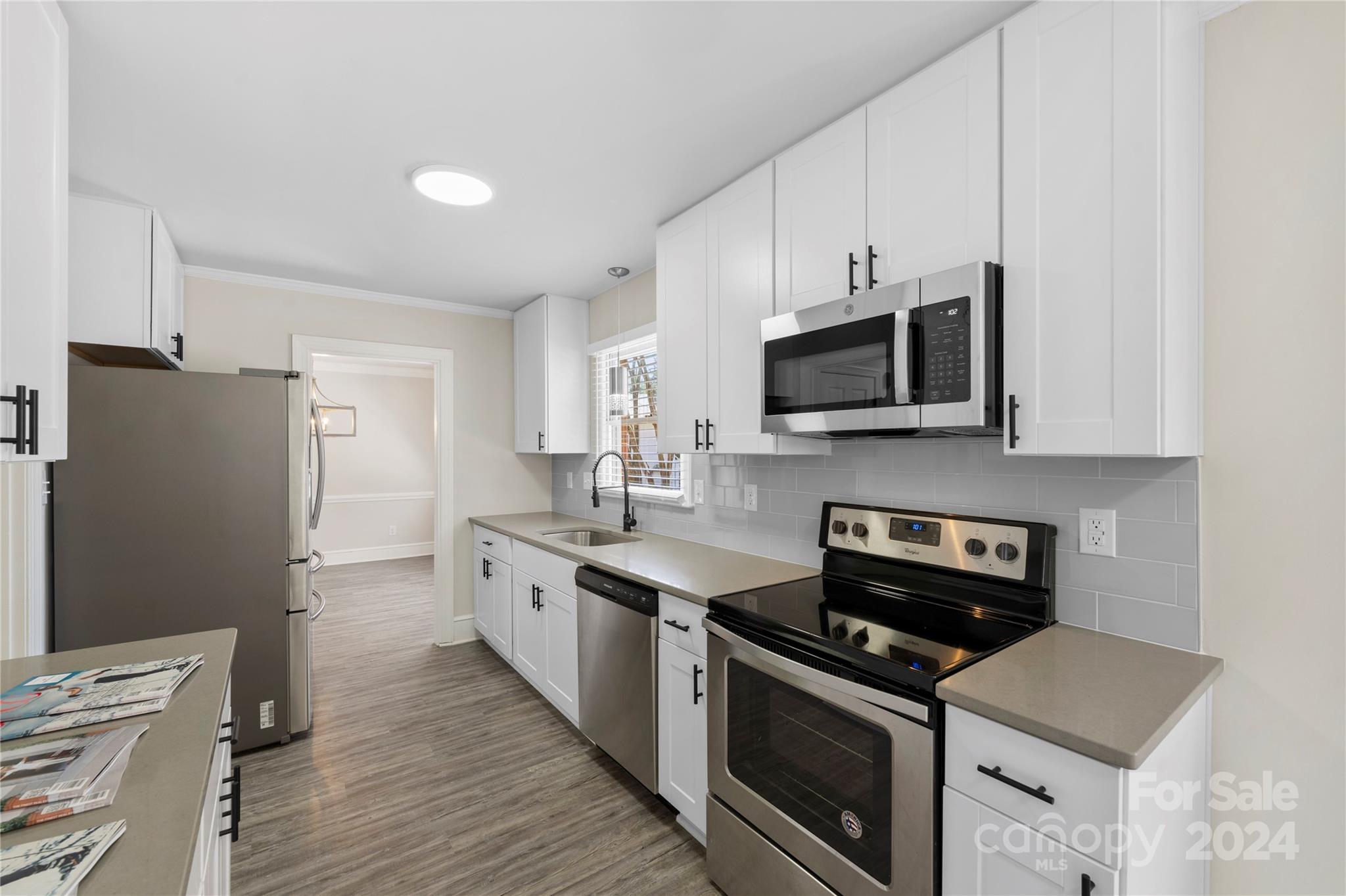 a kitchen with stainless steel appliances a stove microwave and sink