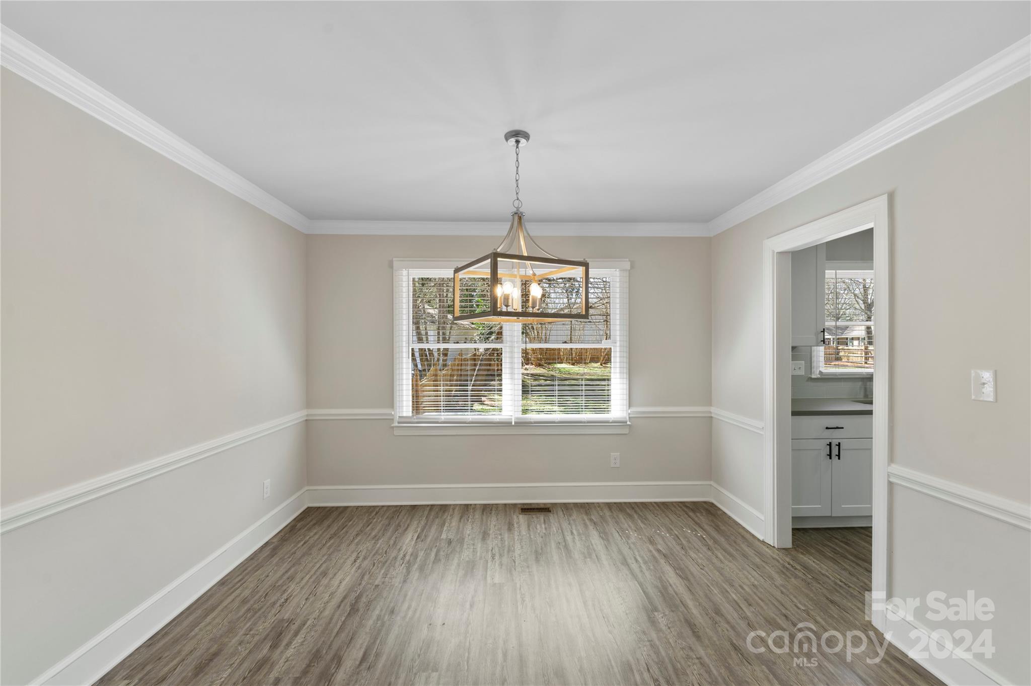 7802 Ridgeloch Place Charlotte, NC 28226 - Photo 9 of 31 an empty room with wooden floor cabinet and windows