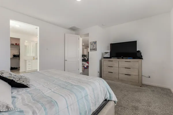 a spacious bedroom with a bed and a dresser