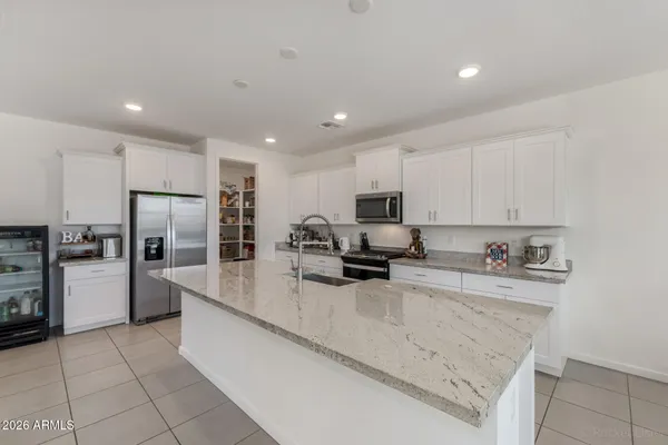 a kitchen with stainless steel appliances granite countertop a refrigerator sink and stove