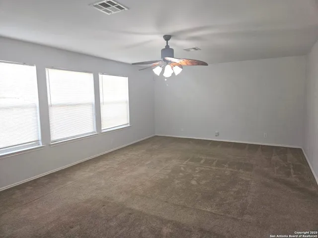 an empty room with chandelier and windows