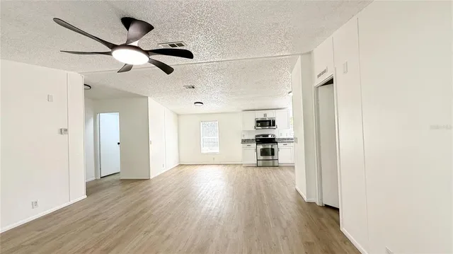 a view of a kitchen with a sink and wooden floor