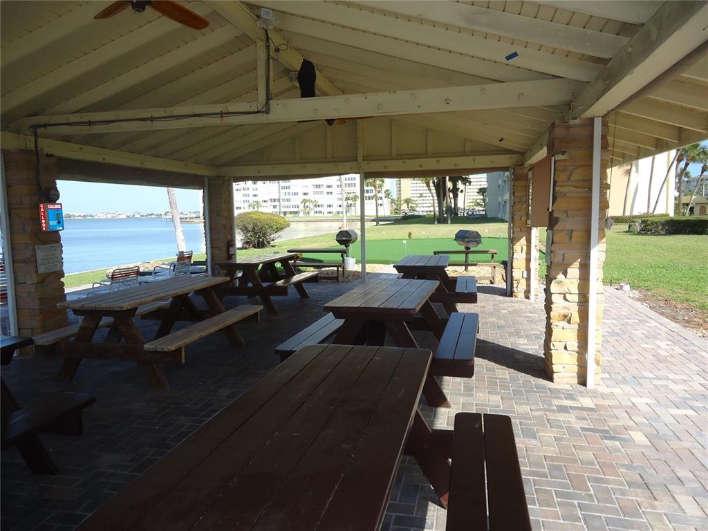 4550 Cove Circle, Unit 405 Madeira Beach, FL 33708 - Photo 17 of 20 a view of a patio with lawn chairs floor to ceiling window with yard
