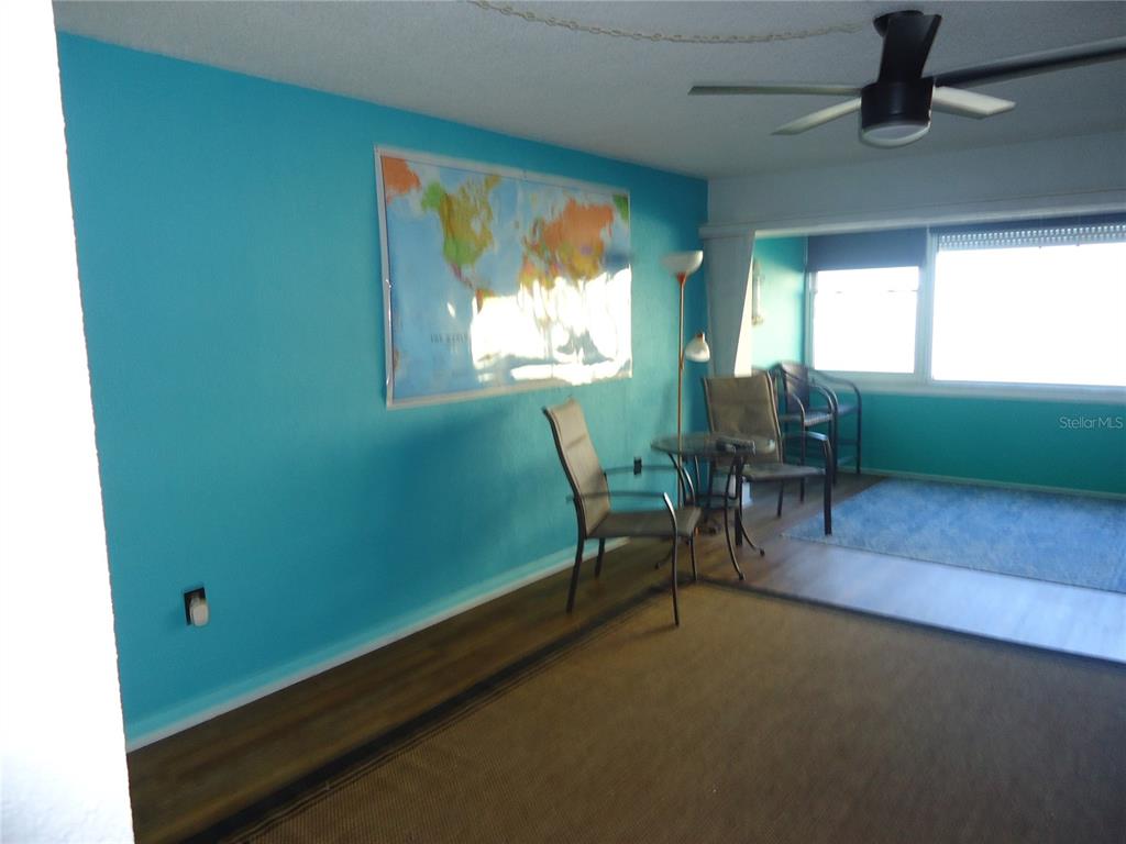 4550 Cove Circle, Unit 405 Madeira Beach, FL 33708 - Photo 6 of 20 a view of a room with furniture and a ceiling fan