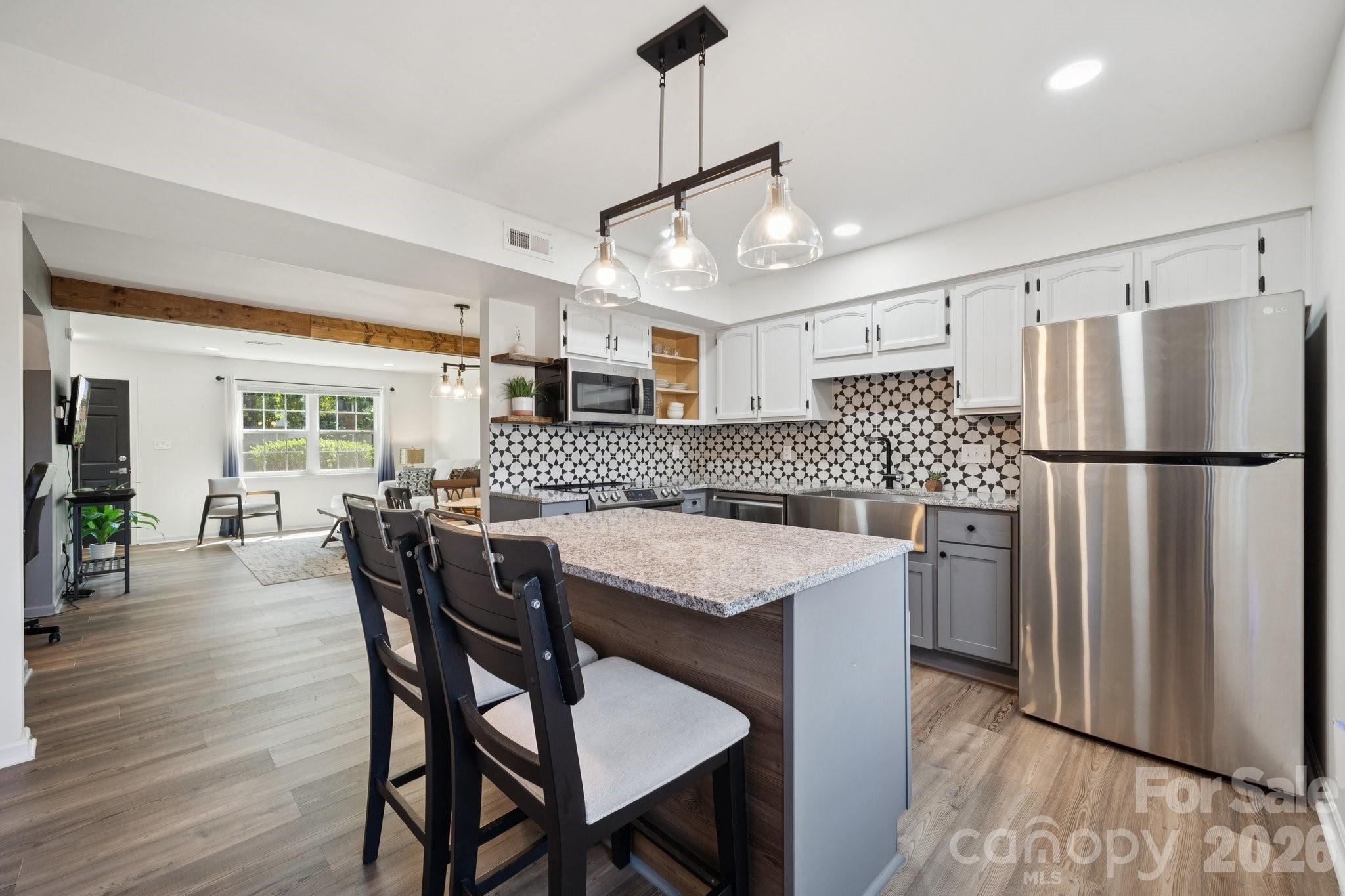 8838 Hunter Ridge Drive Charlotte, NC 28226 - Photo 7 of 27 a kitchen with stainless steel appliances granite countertop a dining table chairs refrigerator and cabinets