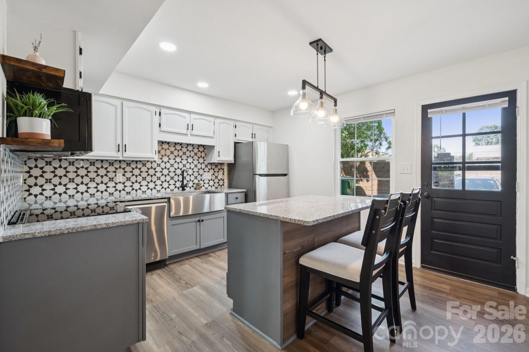 8838 Hunter Ridge Drive Charlotte, NC 28226 - Photo 8 of 27 a kitchen with stainless steel appliances granite countertop a kitchen island a stove a table and chairs in it