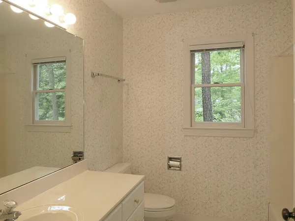 a bathroom with a toilet a sink and a window