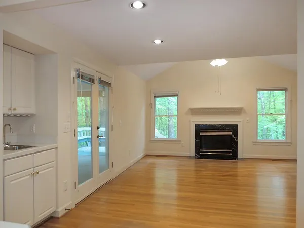 a view of empty room with a fireplace and window