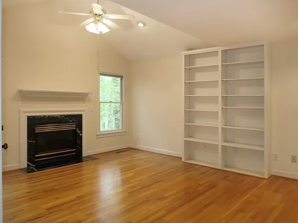 a view of an empty room with a fireplace and a window