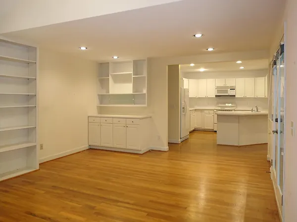 a view of a kitchen with kitchen island a sink wooden floor and a refrigerator