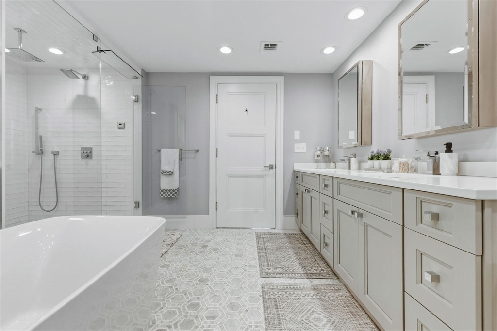 377 West First Street, Unit 5 Boston, MA 02127 - Photo 17 of 27 a spacious bathroom with a mirror a double vanity sink shower and a bathtub