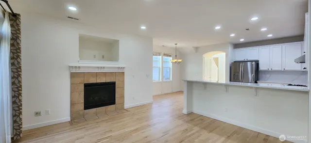 a view of a kitchen with a sink a refrigerator and a fireplace
