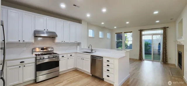 a kitchen with granite countertop white cabinets and white appliances