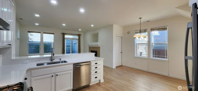 a kitchen with granite countertop a sink and dishwasher with wooden floor