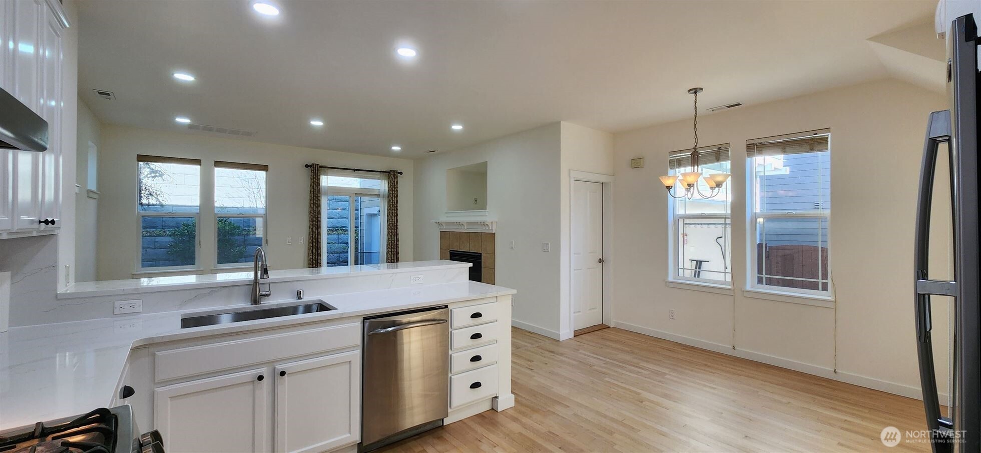 24202 Southeast 21st Street Sammamish, WA 98075 - Photo 10 of 26 a kitchen with granite countertop a sink and dishwasher with wooden floor