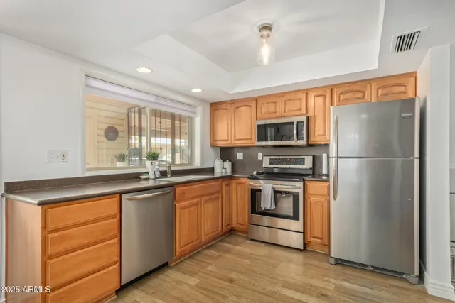 a kitchen with stainless steel appliances granite countertop a refrigerator a stove a sink and a microwave