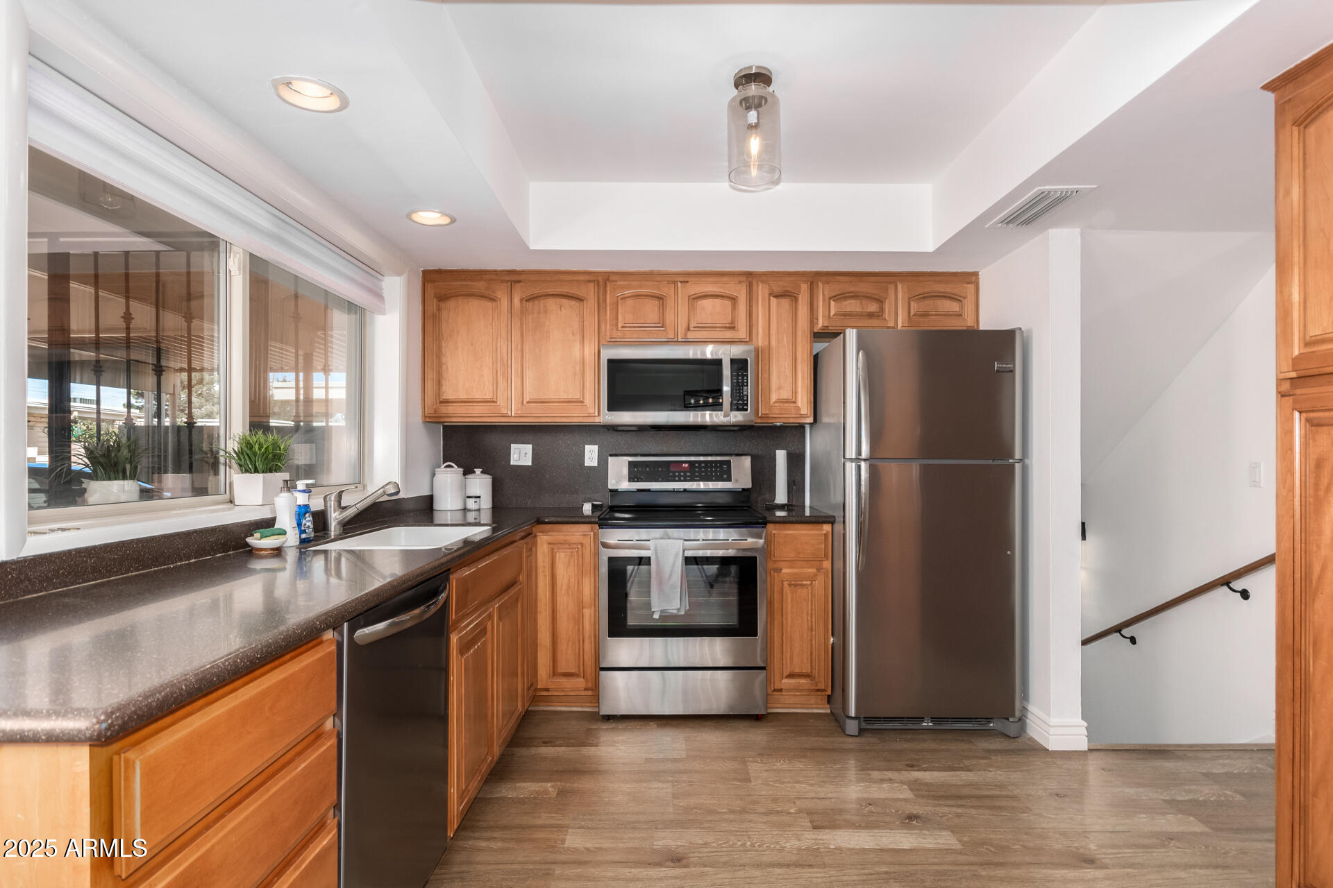 8490 East Chaparral Road Scottsdale, AZ 85250 - Photo 14 of 27 a kitchen with stainless steel appliances granite countertop a refrigerator a stove a sink and a microwave