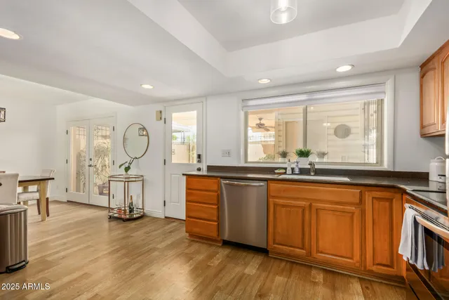 a large kitchen with granite countertop a stove a sink dishwasher a dining table and chair with wooden floor