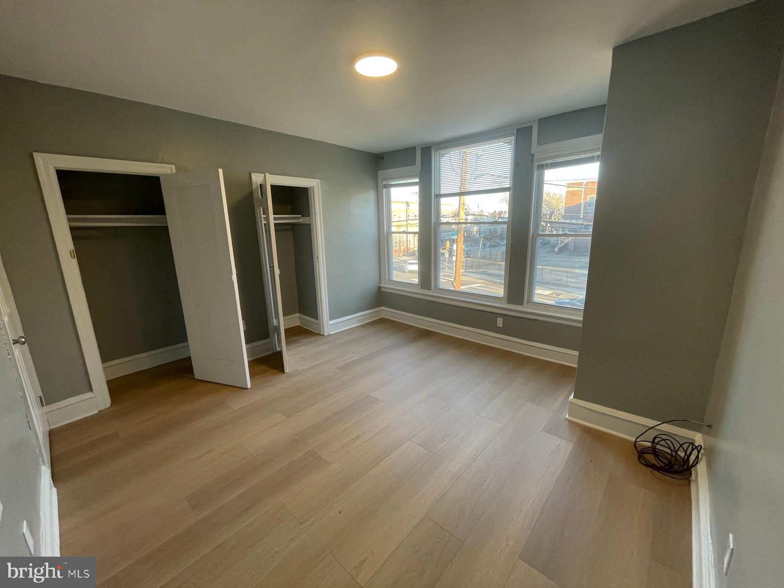 5750-52 Rising Sun Avenue, Unit 2A Philadelphia, PA 19120 - Photo 8 of 22 an empty room with wooden floor and windows