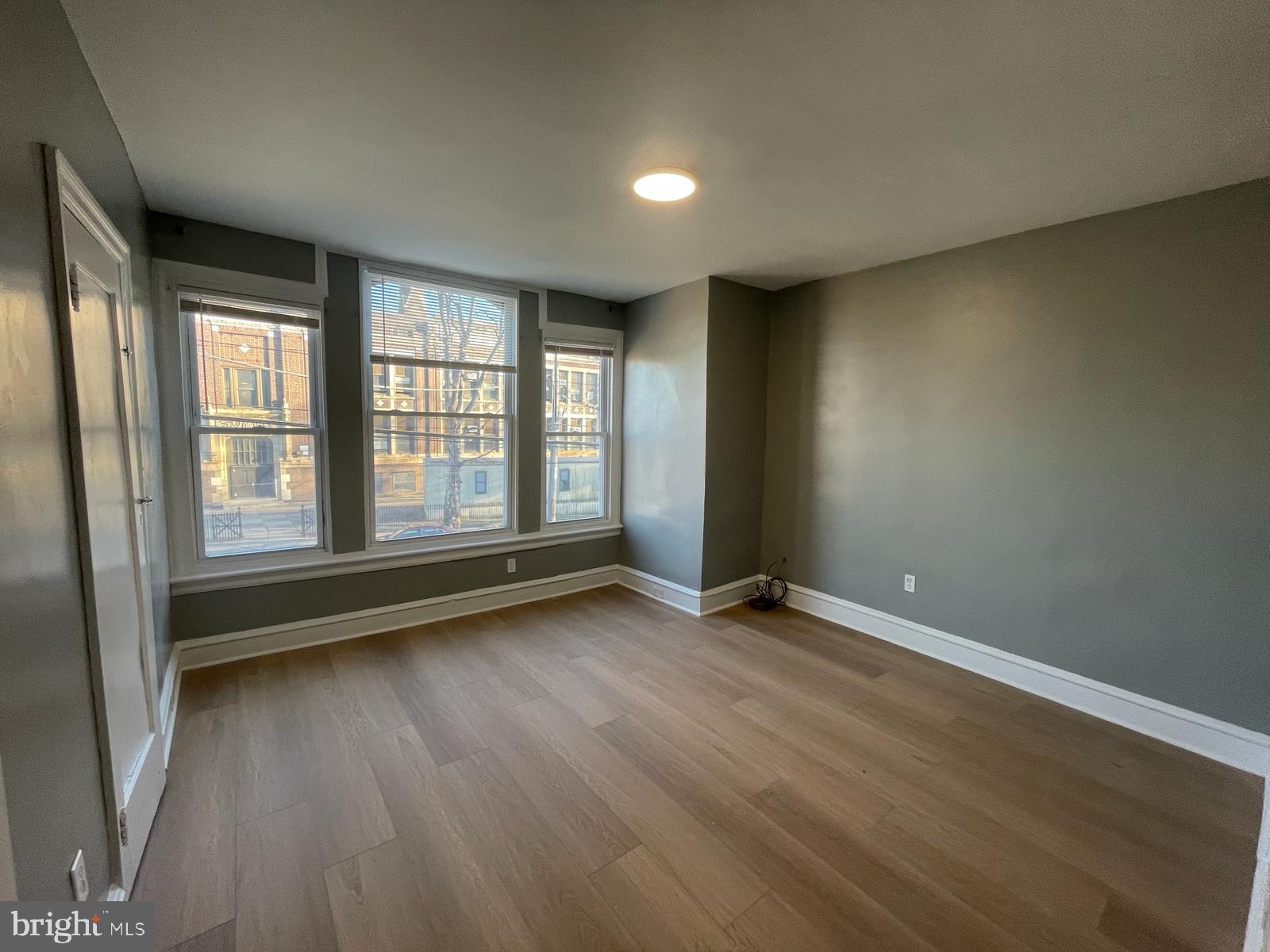 5750-52 Rising Sun Avenue, Unit 2A Philadelphia, PA 19120 - Photo 10 of 22 an empty room with wooden floor and windows