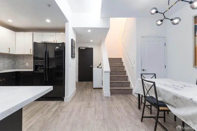 a kitchen with stainless steel appliances wooden floor and chairs