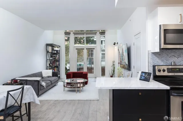 a living room with stainless steel appliances kitchen island granite countertop a couch and a view of living room