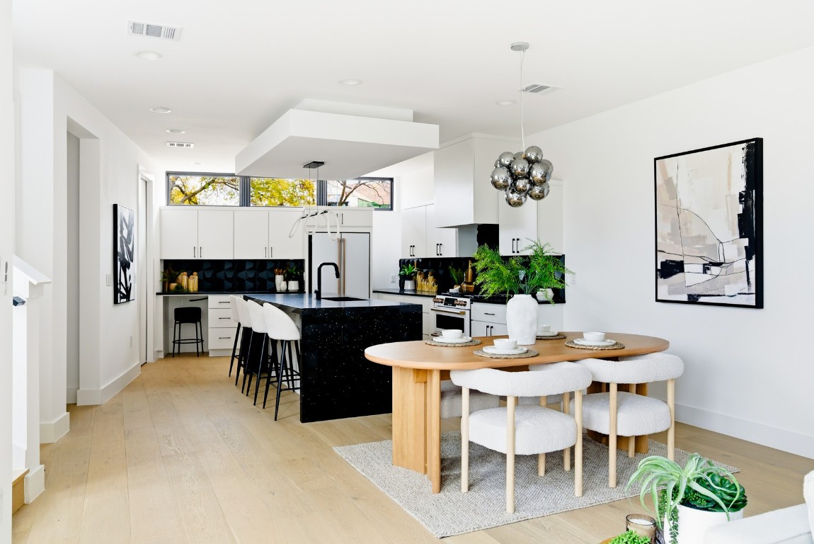 4613 Bolm Road Austin, TX 78702 - Photo 11 of 40 Dining room featuring light wood-style floors and a chandelier