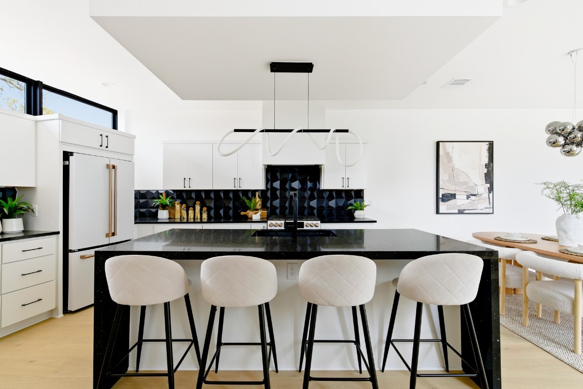 4613 Bolm Road Austin, TX 78702 - Photo 17 of 40 Kitchen with a breakfast bar, white cabinets, and decorative light fixtures
