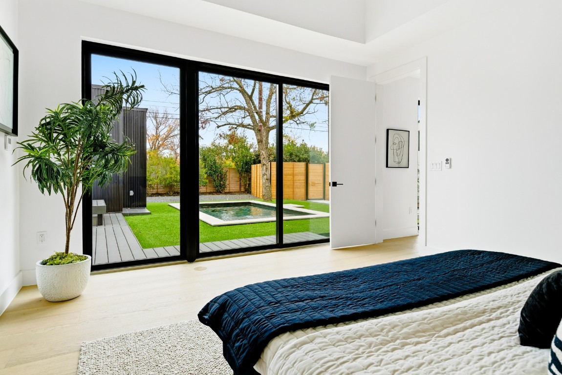 4613 Bolm Road Austin, TX 78702 - Photo 20 of 40 Bedroom with multiple windows, access to exterior, and wood finished floors