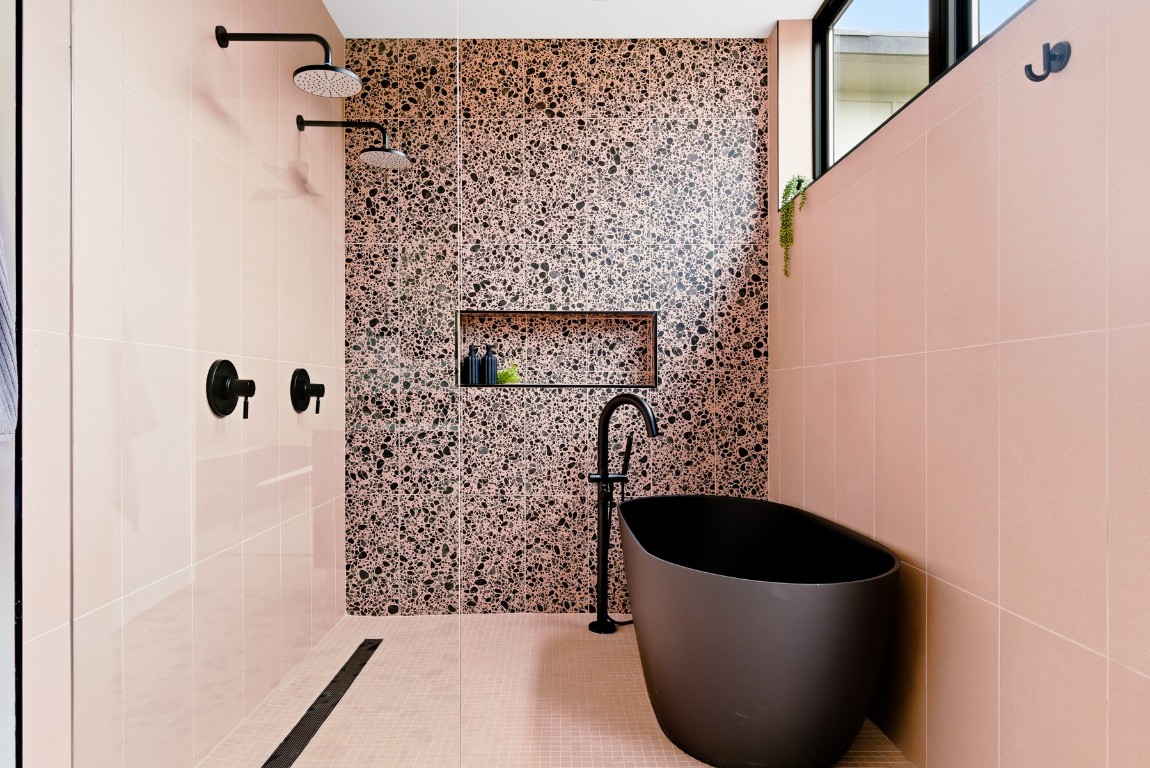 4613 Bolm Road Austin, TX 78702 - Photo 23 of 40 Bathroom with tiled shower, a freestanding bath, tile walls, and tile patterned floors