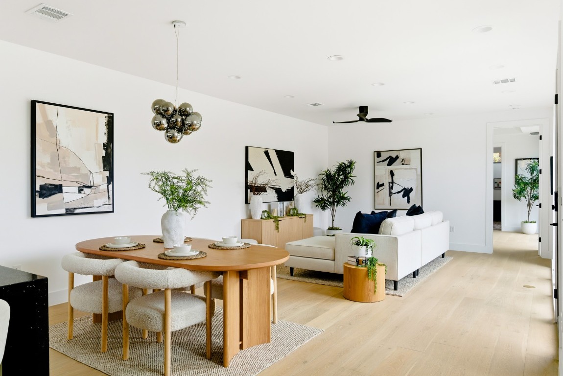 4613 Bolm Road Austin, TX 78702 - Photo 9 of 40 Dining area featuring light wood-style floors, a ceiling fan, and a chandelier