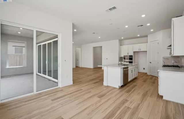 a kitchen with a refrigerator and a stove top oven