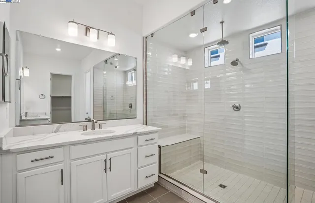 a bathroom with a shower tub double vanity and a mirror
