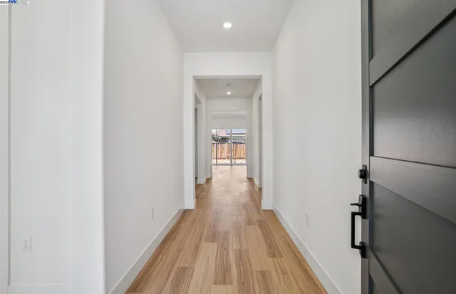 a view of a hallway with wooden floor and staircase