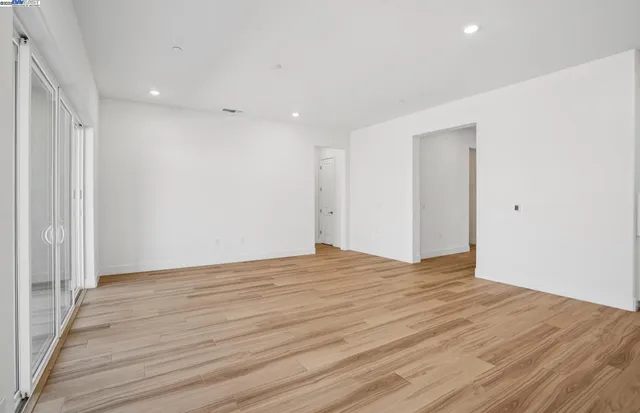 a view of an empty room with wooden floor