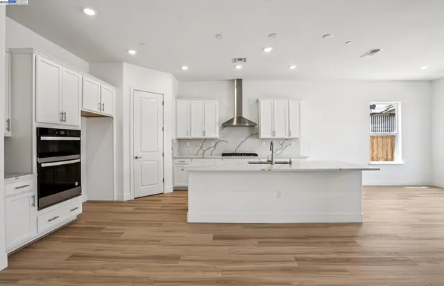 a large kitchen with stainless steel appliances granite countertop a large counter top a stove and a refrigerator