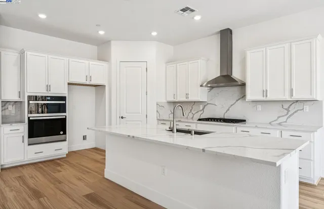 a kitchen with stainless steel appliances a stove a sink and a refrigerator