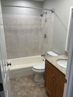 445 Pleasant Street, Unit 32 Weymouth, MA 02190 - Photo 4 of 7 a bathroom with a granite countertop bathtub shower sink vanity and toilet