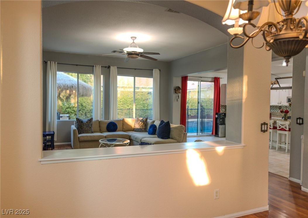 212 Malcolm Street Henderson, NV 89074 - Photo 12 of 47 Living area featuring wood finished floors, ceiling fan, a chandelier, and arched walkways