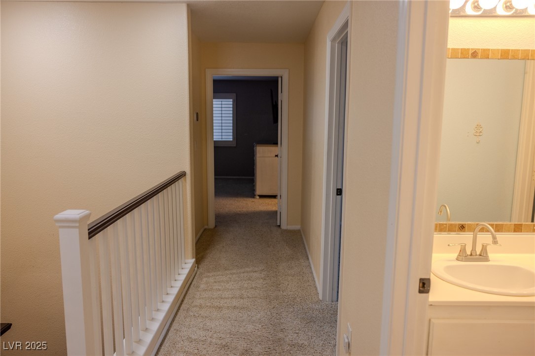 212 Malcolm Street Henderson, NV 89074 - Photo 26 of 47 Hall featuring light colored carpet and an upstairs landing