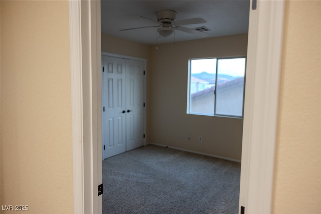 212 Malcolm Street Henderson, NV 89074 - Photo 27 of 47 Unfurnished bedroom featuring carpet - ADDED Bedroom was loft> Upstairs. flooring, a ceiling fan, and a closet. This Room added- was loft.