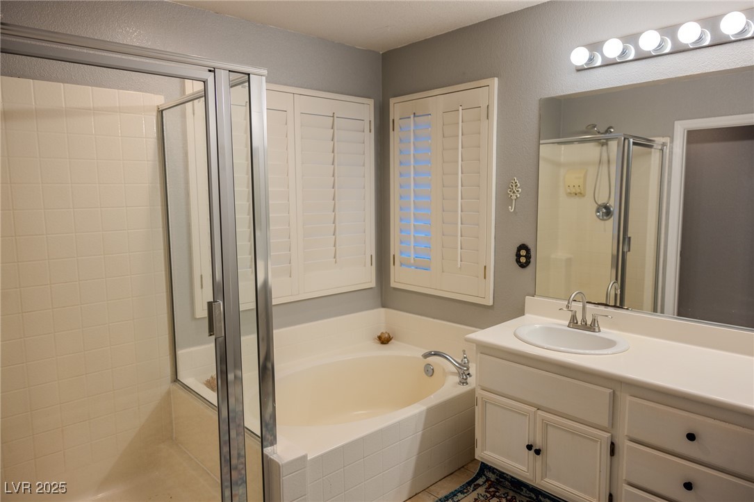 212 Malcolm Street Henderson, NV 89074 - Photo 32 of 47 Full bathroom - Primary Bathroom. featuring a shower stall, a bath, and vanity
