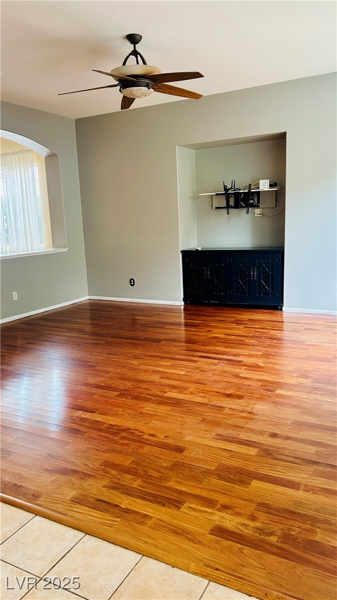 212 Malcolm Street Henderson, NV 89074 - Photo 40 of 47 Unfurnished living room featuring wood floors ceiling fan, and arched wall accent
