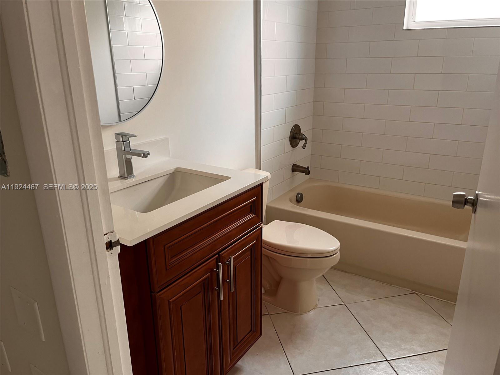 181 Northwest 47th Avenue, Unit 8 Miami, FL 33126 - Photo 10 of 22 a bathroom with a sink a toilet and a mirror