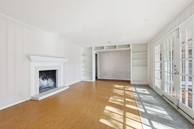 a view of an empty room with a fireplace and a window