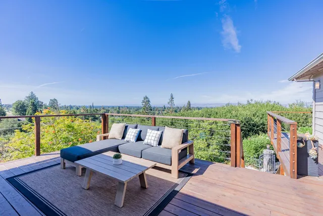 a view of a patio with table and chairs with wooden floor and fence