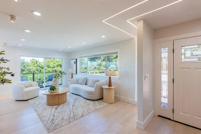 a living room with patio furniture and a potted plant