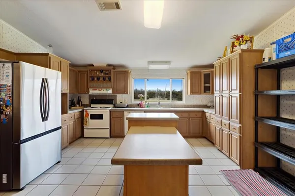 a kitchen with stainless steel appliances a refrigerator sink and cabinets