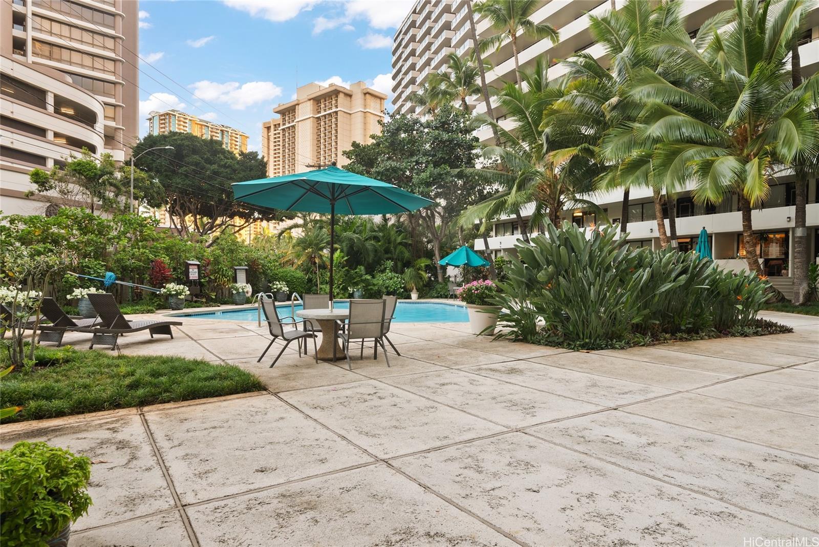 425 Ena Road, Unit B602 Honolulu, HI 96815 - Photo 11 of 16 a view of a patio with a table and chairs under an umbrella